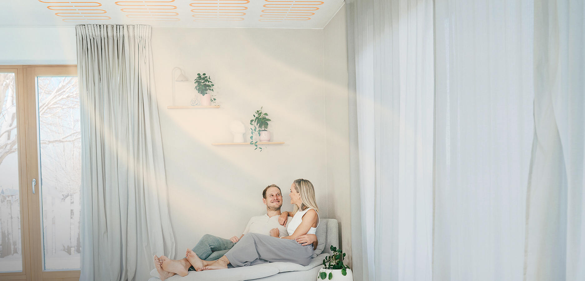 Paar sitzt zuhause und genießt naturbo Deckenheizung / -Kühlung