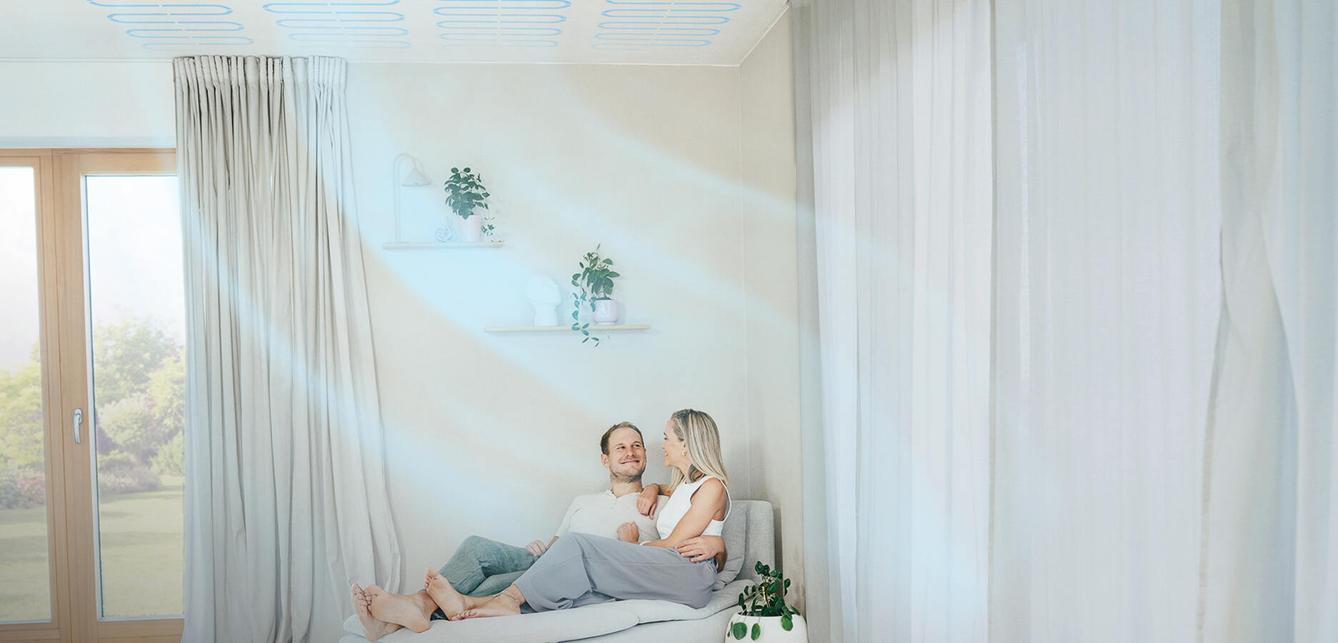 Paar sitzt zuhause und genießt naturbo Deckenheizung / -Kühlung