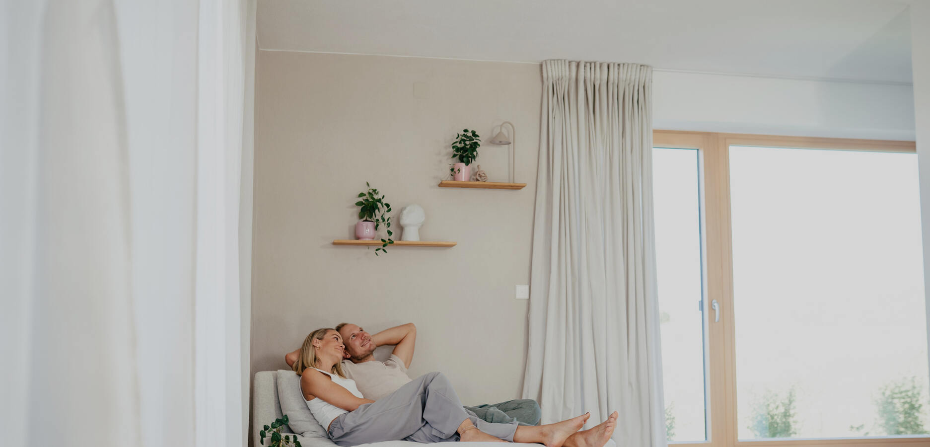 paar genießt auf der couch heiz- und kühldecke von naturbo